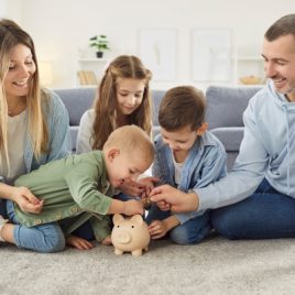 Young Family, putting money in piggy bank_sq